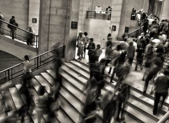Blurred photo in B and W of people moving fast through stairs